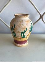 Front view of mini ceramic vase showing green cactus plant designs