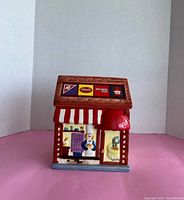 Front view of the colorful large candy store front cookie jar displaying a chef figure and signage