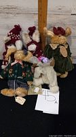 Five Boyds Bears bunnies posed frontally including a brown bunny in green jacket and tan one in green dress, measuring scale included