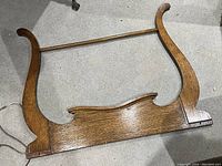 Top view of antique dresser harp showing wood grain and curved sides