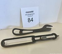 Front view of two antique metal can openers showing their length and blade designs