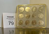 Plastic encased set of 12 Canadian provincial quarters with display stand and seller auction number.