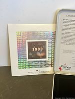 Holographic 1999 Canadian stamp with peace-themed text on a card.