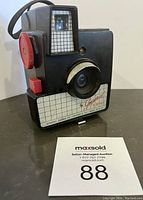 Front view of the vintage Kodak Square Shooter camera showing lens, shutter button, and label.