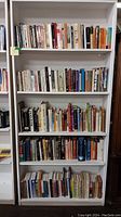 Full bookshelf with five shelves of assorted books