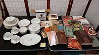 Full lot view showing Johann Haviland china dinnerware and assortment of vintage and mid-century cookbooks.