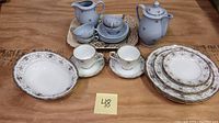 Overview of mixed china and teaware set including Thun periwinkle floral pieces, Noritake Astorbrook tea cups and saucers, and vintage Melbourne transferware platter.