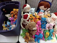 Photo of various colorful souvenir Beanie Bears, Bookcraft Santa and Mrs. Claus dolls, large plush dog, and a boxed Rosie O'Donnell doll.