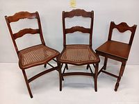 Three vintage wooden chairs grouped together, two with woven cane seats and one with solid wooden seat, showing overall condition and style.