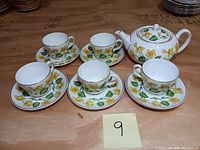 Overview photo of the teapot, five teacups, and saucers showing the Kingcup floral pattern and gold trim.