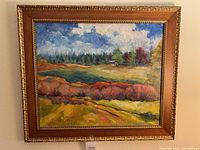Full view of the framed landscape oil painting by Nancy Cowan with a gold ornate and wood frame.