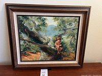 Framed oil painting showing a child sitting on a large tree branch in a landscape setting with visible brushwork and foliage.