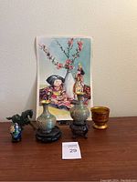Overall view of Asian art decor items including vases, figurines, painted cup, and artwork.