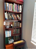 Full view of bookshelf filled with books and decorative items, showing organization and condition