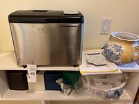 Breadman Ultimate Plus bread maker full side view showing stainless steel finish on a white shelf.