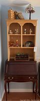 Full view of the wood secretary desk with hutch and assembled decorative items.