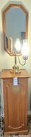 Full view of the wooden jewelry box with hinged lid and octagonal wooden-framed mirror mounted above. Brass oil lamp style table lamp with glass chimney is on the jewelry box top.