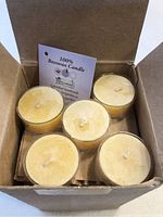 View inside the box showing 5 visible beeswax tealight candles with a small information card inside the box stating 100% Beeswax Candle, Canadian handmade.