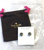 Full view of Kate Spade earrings on a branded card beside the black Kate Spade pouch with pink drawstrings.