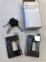 Two new FJM Security Products locks with three matching keys and white original packaging box shown on white background.
