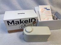 MakeID L1 label printer and original box with instruction leaflet inside the box.