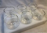 Photo showing all six clear double-walled drinking glasses arranged on a white surface.