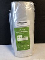 Package of vacuum sealer bags wrapped in clear plastic showing label with quantity and sizes.