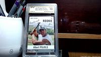 Front view of Albert Pujols rookie card graded Gem Mint 10, showing the player in batting position and the grading label on top.