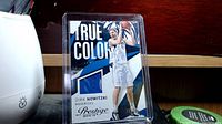 Front view of Dirk Nowitzki basketball card in plastic case showing True Colors series and embedded blue jersey swatch.