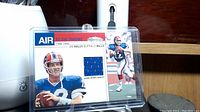 Front view of Jim Kelly trading card showing a blue jersey swatch and color photo of Jim Kelly in Bills uniform.