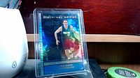 Front of Steve Nash basketball jersey card showing holographic image and embedded jersey swatch inside protective case.