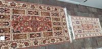 Both rugs laid side by side on carpeted floor showing full patterns and relative sizes.