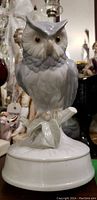 Front view of the porcelain owl music box, showing detailed owl face and branch base.