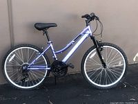 Side view of the purple Huffy Rockcreek girls mountain bike showing the full bike profile with tire, saddle, handlebars, and frame.