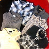 Lot of six men's XL sized tops laid out, various collared shirts and polos visible.