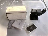 Camera platform, mounting hardware, instruction manual, and original white box on outdoor surface.