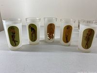 Front view of five pinup keyhole glasses showing colorful vintage pinup images on frosted glass