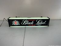 Front view of the vintage Carling Black Label TV Beer illuminated sign lit up on a white surface.