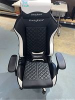 Front view of black and white DXRacer Acer gaming chair showing quilted pattern on seat and backrest with DXRacer branded removable neck and lumbar cushions.