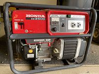 Front view showing red metal frame, Honda EM2500 label, engine switch and control panel