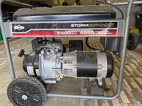 Side view showing the Briggs & Stratton Storm Responder branding with 5500 watts running power and 8250 starting watts labels. Shows the engine and generator assembly mounted on a metal frame with wheels.