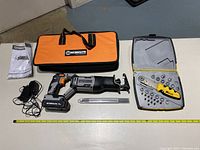 Full lot display showing two primary items: Worksite reciprocating saw kit and Zip Wrench case with tools inside, also includes instruction manual and saw blades.