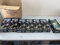 Photo showing all seven boxed 12 inch Star Wars figures lined up on table, six Cantina Band and one action collection figure.