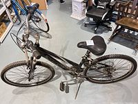 Side view of black and silver Trek Navigator 200 girls bike showing frame, tires, pedals, seat and handlebars