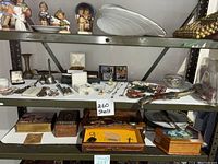 Shelf view showing brass decor items, jewelry boxes, and assorted small collectibles