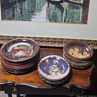 Overview of the stacked Christmas plates on a wooden table, showing multiple designs and sizes.