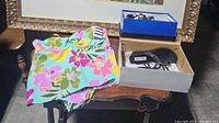 Photo showing folded Lands End floral tankini on table next to two boxes containing pairs of sandals.