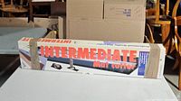 Photo of boxed Logan Intermediate mat cutter showing front packaging and branding.