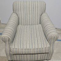 Front view of the multicolored striped upholstered rocker chair showing cushioned armrests and removable seat cushion.