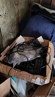 Photo of box showing tangled cables and black electronic devices